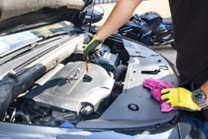 A man performing maintenance on a car engine, focusing on changing the oil.